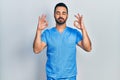 Handsome hispanic man with beard wearing blue male nurse uniform relax and smiling with eyes closed doing meditation gesture with Royalty Free Stock Photo