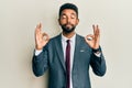 Handsome hispanic man with beard wearing business suit and tie relaxed and smiling with eyes closed doing meditation gesture with Royalty Free Stock Photo