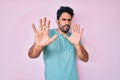 Handsome hispanic man with beard wearing casual clothes afraid and terrified with fear expression stop gesture with hands, Royalty Free Stock Photo