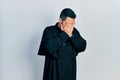 Handsome hispanic man with beard wearing catholic priest robe with sad expression covering face with hands while crying Royalty Free Stock Photo