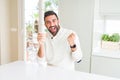 Handsome hispanic man drinking a coffee in a paper cup screaming proud and celebrating victory and success very excited, cheering Royalty Free Stock Photo