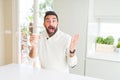 Handsome hispanic man drinking a coffee in a paper cup very happy and excited, winner expression celebrating victory screaming Royalty Free Stock Photo