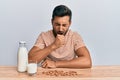 Handsome hispanic man drinking healthy almond milk feeling unwell and coughing as symptom for cold or bronchitis Royalty Free Stock Photo