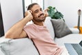 Handsome hispanic man relaxing on the sofa listening to music at the living room at home Royalty Free Stock Photo