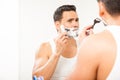 Handsome Hispanic man shaving his beard