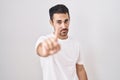 Handsome hispanic man standing over white background pointing with finger up and angry expression, showing no gesture Royalty Free Stock Photo