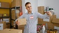 Handsome hispanic man taking a selfie in a warehouse holding cardboard box Royalty Free Stock Photo