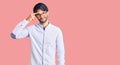 Handsome hispanic man wearing business shirt and glasses pointing unhappy to pimple on forehead, ugly infection of blackhead Royalty Free Stock Photo