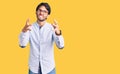 Handsome hispanic man wearing business shirt and glasses shouting frustrated with rage, hands trying to strangle, yelling mad Royalty Free Stock Photo