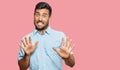 Handsome hispanic man wearing casual clothes afraid and terrified with fear expression stop gesture with hands, shouting in shock Royalty Free Stock Photo