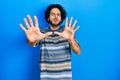 Handsome hispanic man wearing casual clothes over pink background afraid and terrified with fear expression stop gesture with Royalty Free Stock Photo
