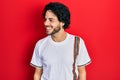 Handsome hispanic man wearing casual white t shirt looking away to side with smile on face, natural expression Royalty Free Stock Photo