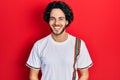 Handsome hispanic man wearing casual white t shirt looking positive and happy standing and smiling with a confident smile showing Royalty Free Stock Photo