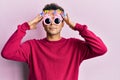 Handsome hispanic man wearing funny happy birthday glasses with hand on head, headache because stress