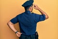 Handsome hispanic man wearing police uniform backwards thinking about doubt with hand on head