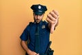 Handsome hispanic man wearing police uniform looking unhappy and angry showing rejection and negative with thumbs down gesture Royalty Free Stock Photo