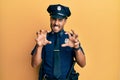 Handsome hispanic man wearing police uniform smiling funny doing claw gesture as cat, aggressive and sexy expression Royalty Free Stock Photo