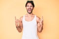 Handsome hispanic man wearing summer look and sunglasses shouting with crazy expression doing rock symbol with hands up Royalty Free Stock Photo