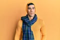 Handsome hispanic man wearing wool hat and winter scarf relaxed with serious expression on face Royalty Free Stock Photo