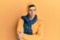 Handsome hispanic man wearing wool hat and winter scarf skeptic and nervous, disapproving expression on face with crossed arms Royalty Free Stock Photo