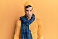 Handsome hispanic man wearing wool hat and winter scarf skeptic and nervous, frowning upset because of problem Royalty Free Stock Photo