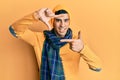 Handsome hispanic man wearing wool hat and winter scarf smiling making frame with hands and fingers with happy face Royalty Free Stock Photo