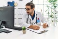 Handsome hispanic man working as doctor writing pills presciption at hospital clinic