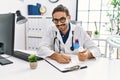 Handsome hispanic man working as doctor writing pills presciption at hospital clinic