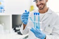 Handsome hispanic man working as scientific holding test tubes at laboratory Royalty Free Stock Photo