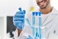 Handsome hispanic man working as scientific holding test tubes at laboratory Royalty Free Stock Photo