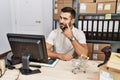 Handsome hispanic man working at small business commerce pointing to the eye watching you gesture, suspicious expression Royalty Free Stock Photo