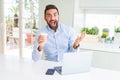 Handsome hispanic man working using computer laptop and drinking a cup of coffee very happy and excited, winner expression Royalty Free Stock Photo