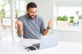 Handsome hispanic man working using computer laptop screaming proud and celebrating victory and success very excited, cheering Royalty Free Stock Photo