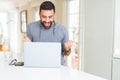 Handsome hispanic man working using computer laptop screaming proud and celebrating victory and success very excited, cheering Royalty Free Stock Photo