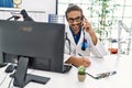 Handsome hispanic man writing presciption on the phone at hospital clinic