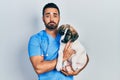 Handsome hispanic veterinary man with beard checking dog health depressed and worry for distress, crying angry and afraid Royalty Free Stock Photo