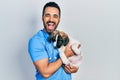 Handsome hispanic veterinary man with beard checking dog health smiling and laughing hard out loud because funny crazy joke Royalty Free Stock Photo