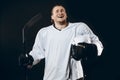 Handsome hockey player. Smiling at camera isolated on black background.