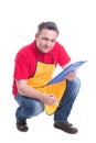 Handsome hypermarket employee writing on clipboard Royalty Free Stock Photo