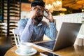 Handsome indian man working in cafe. Closeup man face sitting in front of laptop computer and thinking about business projects Royalty Free Stock Photo