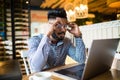 Handsome indian man working in cafe. Closeup man face sitting in front of laptop computer and thinking about business projects Royalty Free Stock Photo