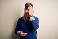 Handsome Irish redhead business man with beard standing over isolated background covering one eye with hand, confident smile on Royalty Free Stock Photo