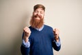 Handsome Irish redhead business man with beard standing over isolated background excited for success with arms raised and eyes Royalty Free Stock Photo