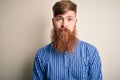 Handsome Irish redhead business man with beard standing over isolated background with serious expression on face Royalty Free Stock Photo