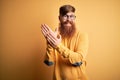 Handsome Irish redhead man with beard wearing glasses over yellow isolated background clapping and applauding happy and joyful, Royalty Free Stock Photo