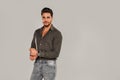 Handsome, irresistible man looking at the camera. Good looking young male model posing against light grey background Royalty Free Stock Photo