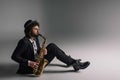 handsome jazzman playing saxophone while sitting