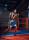 Handsome kick boxer training kicking and punching boxing bag