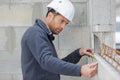 handsome laborer with pencil measuring wall with level tool Royalty Free Stock Photo