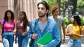 Handsome latin american male student with group of caucasian and african american young adults Royalty Free Stock Photo